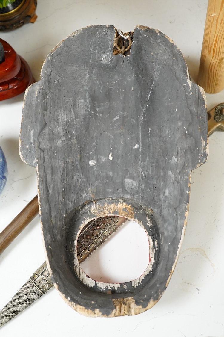 An African hardwood throwing club together with a painted mask and a Caucasian style dagger kindjal, largest 34cm high
